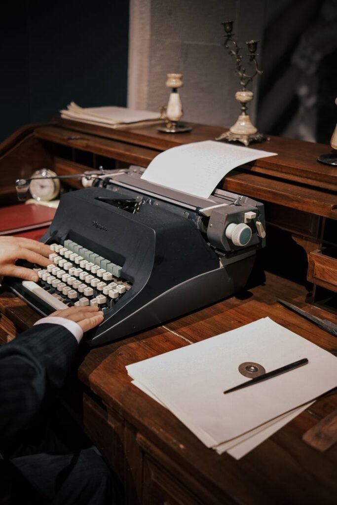 Old-fashioned typewriter on desk with papers, ideal for vintage business concepts.