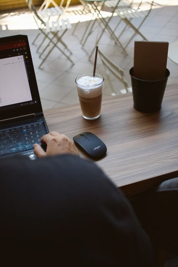 Casual workspace in a cafe with laptop and coffee.